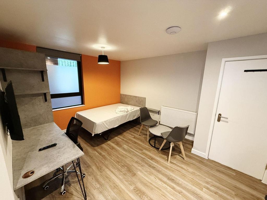 A bright and modern double bedroom featuring st...