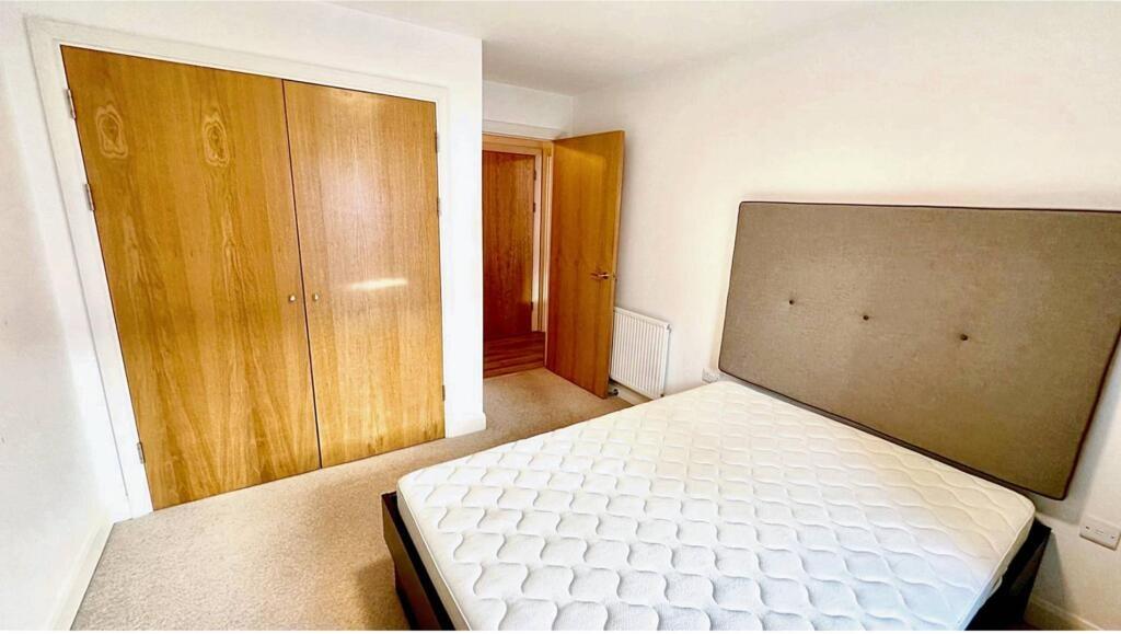 Bright double bedroom featuring a large window ...
