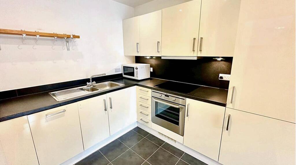 Modern and tidy kitchen featuring sleek white c...