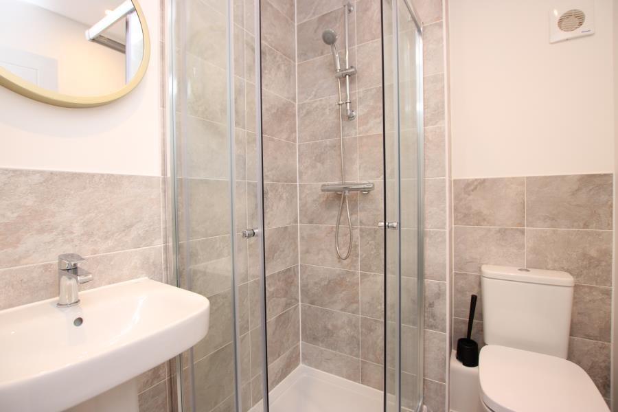 Bright, modern bathroom featuring a glass-enclo...