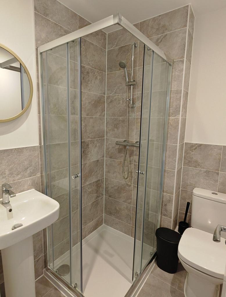 Modern bathroom featuring a clean, glass-enclos...