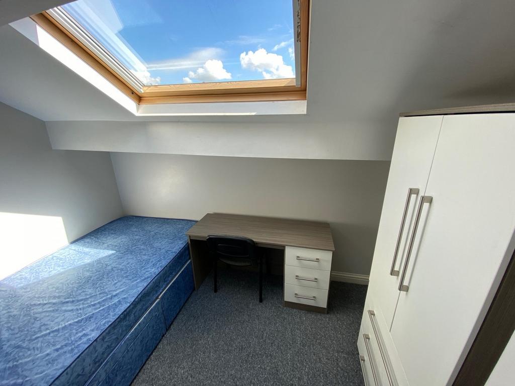 A bright and inviting double bedroom with a com...