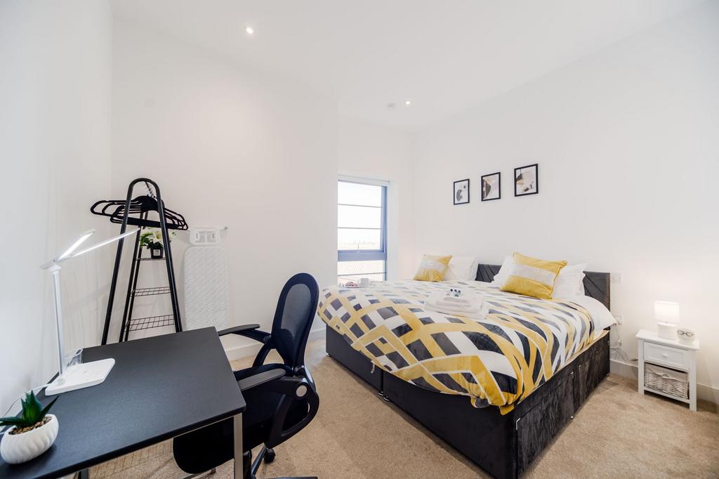 Bright and modern master bedroom featuring a co...