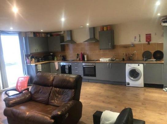 Spacious modern kitchen area with sleek grey ca...