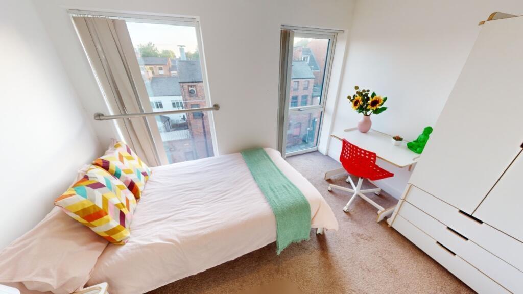Bright and cozy single bedroom featuring a comf...
