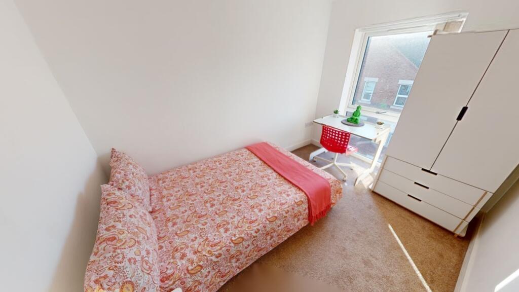 A bright and tidy single bedroom featuring a co...