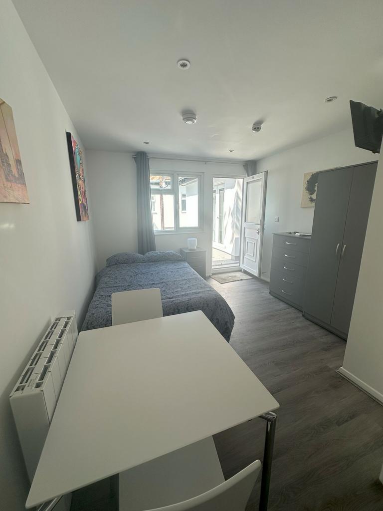 A bright and neat double bedroom featuring mode...