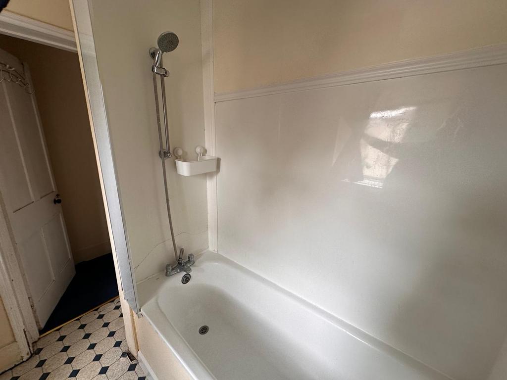 Simple, functional bathroom with a bathtub and ...