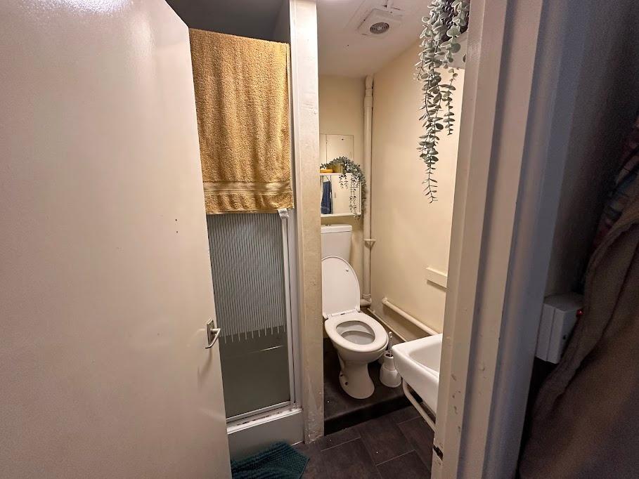 Compact and functional bathroom featuring a sho...