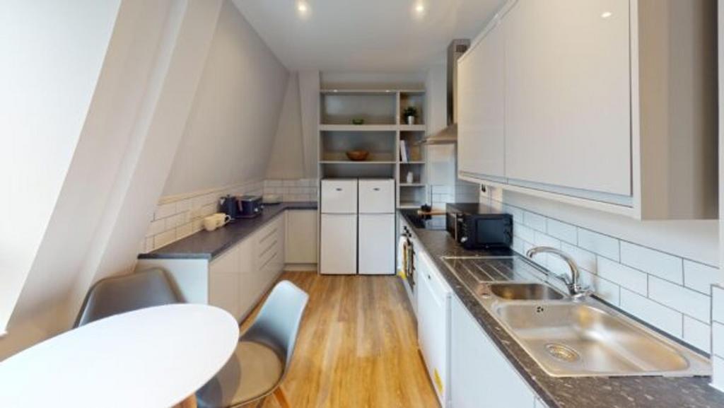A bright and modern kitchenette with sleek desi...