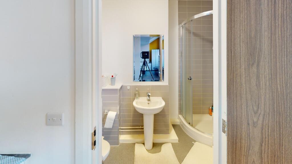 A clean and well-lit bathroom with a large bath...