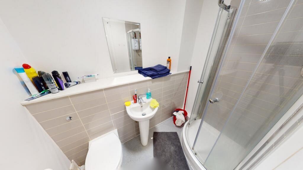 A modern bathroom featuring a spacious shower e...