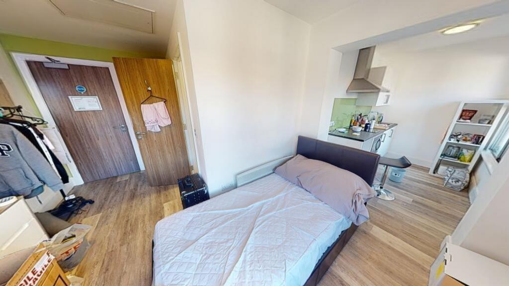 Spacious double bedroom featuring a cozy bed, a...
