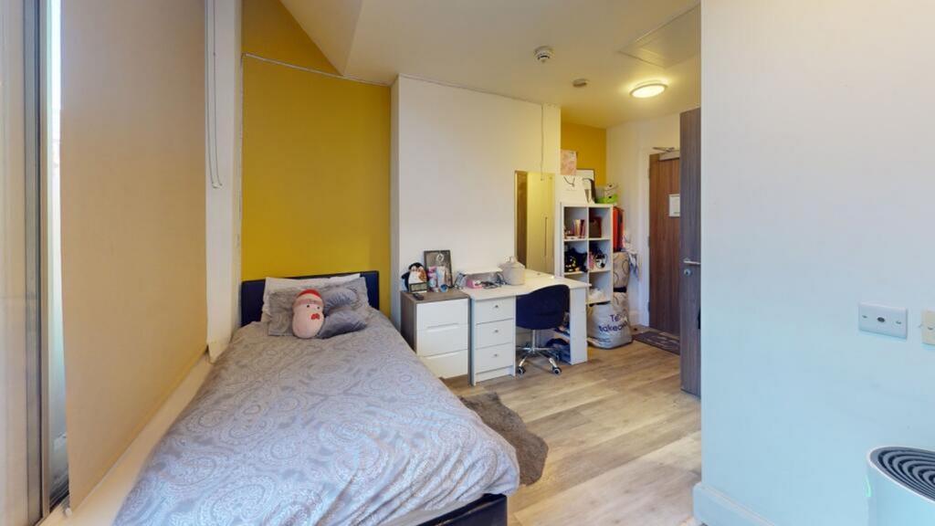 This cozy single bedroom features a comfortable...