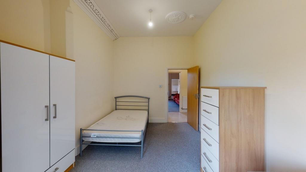 A simple and tidy bedroom featuring a single be...