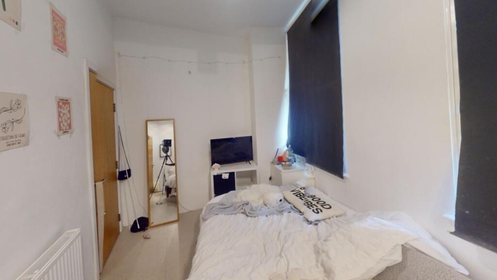 Cozy bedroom featuring a comfortable single bed...