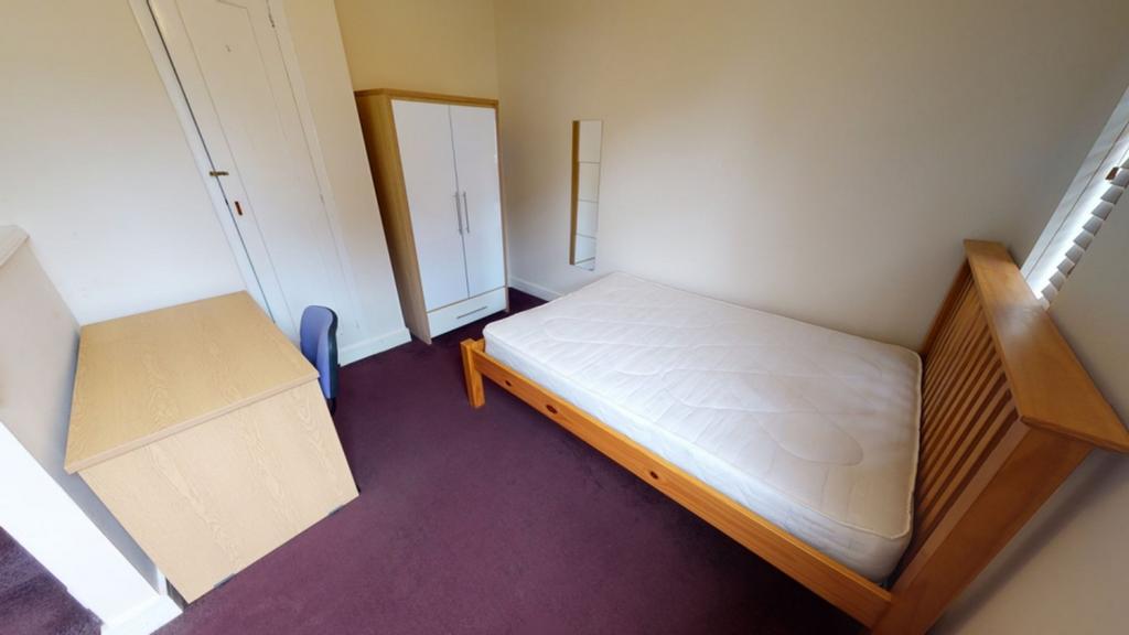 A bright and tidy double bedroom featuring esse...
