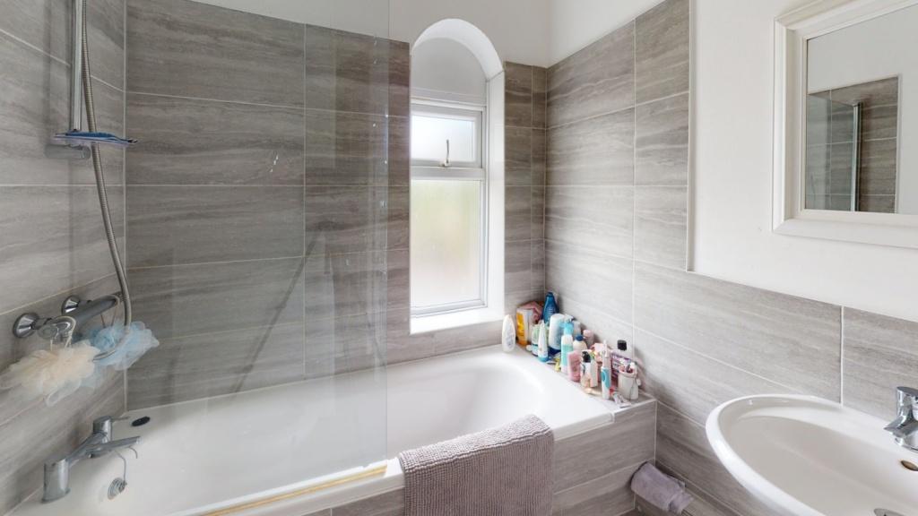 A modern bathroom suite featuring a bathtub wit...