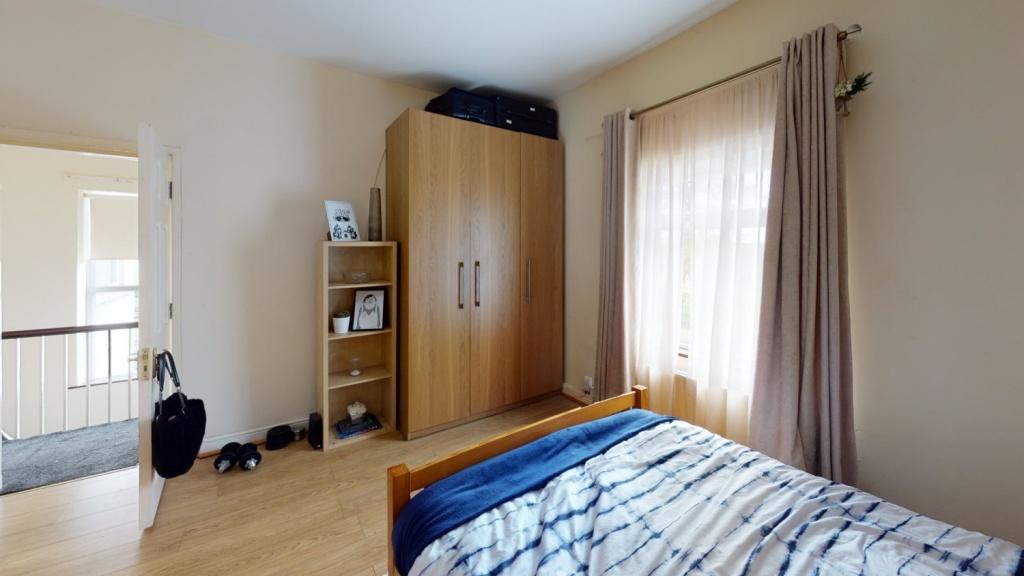 A cozy single bedroom featuring a comfortable b...