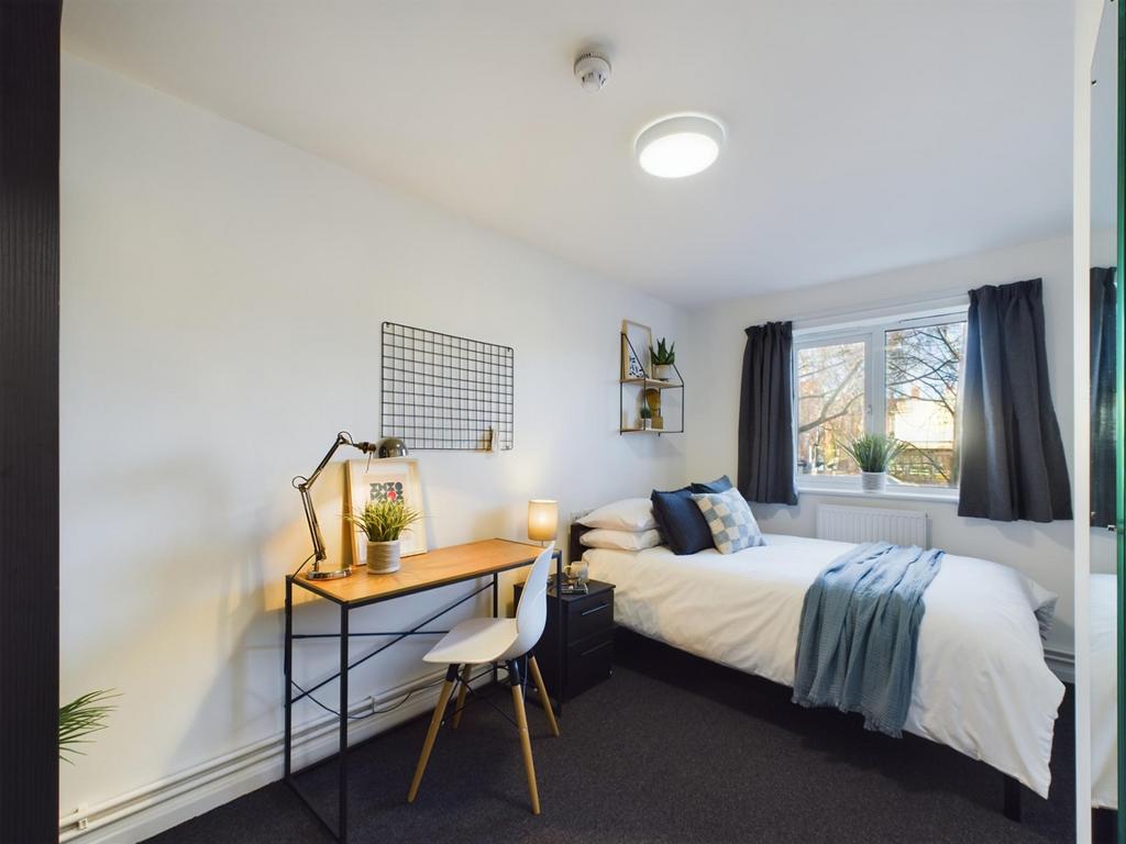 A bright and inviting double bedroom with a com...