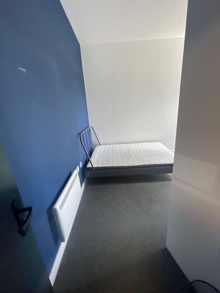 A simple bedroom featuring a clean white mattre...