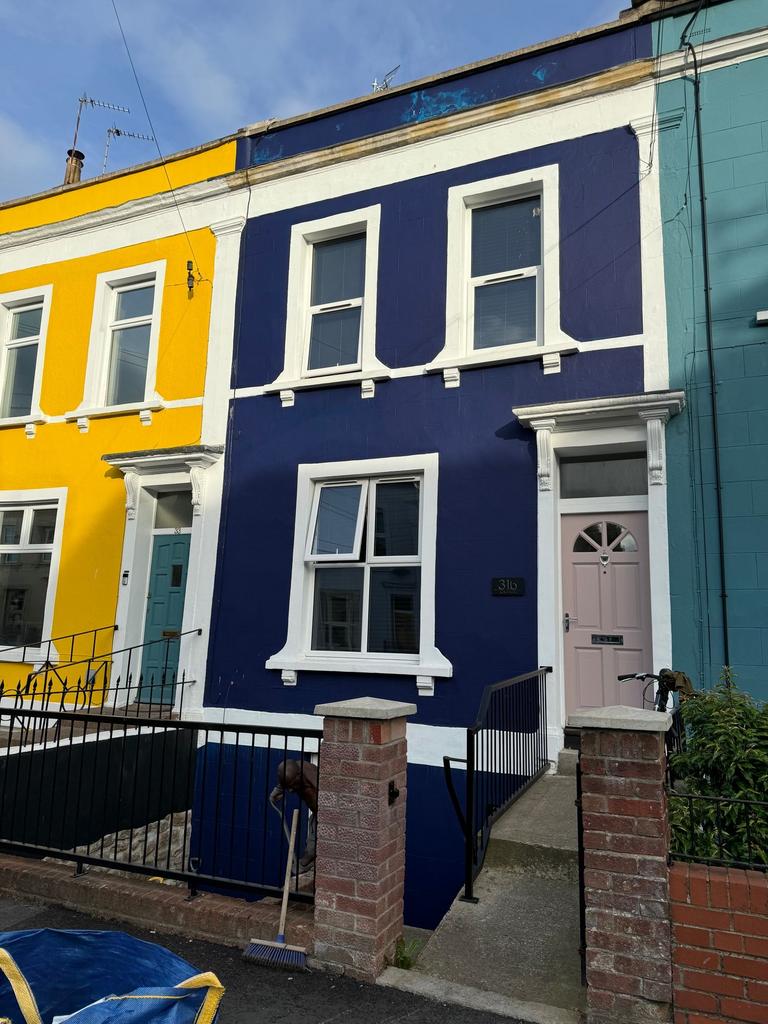 Vibrantly painted terraced houses with bold yel...