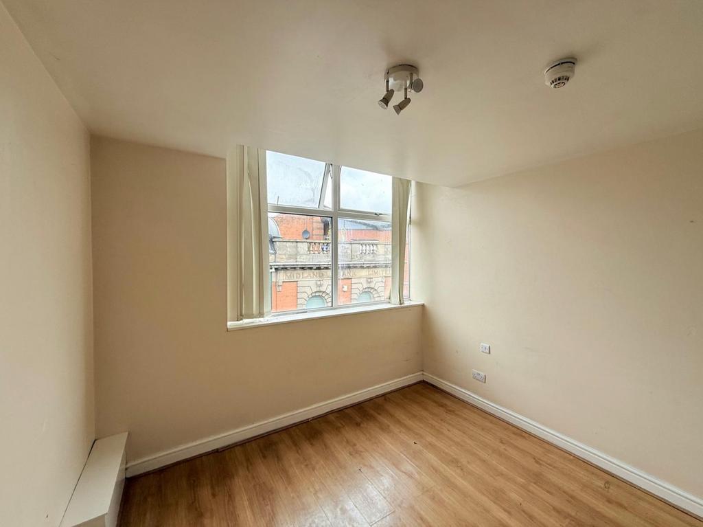 A bright and tidy empty single bedroom featurin...