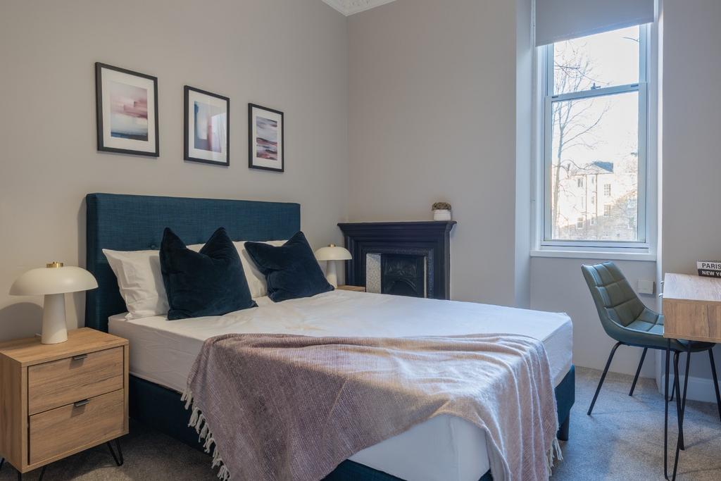A stylish master bedroom featuring a comfortabl...