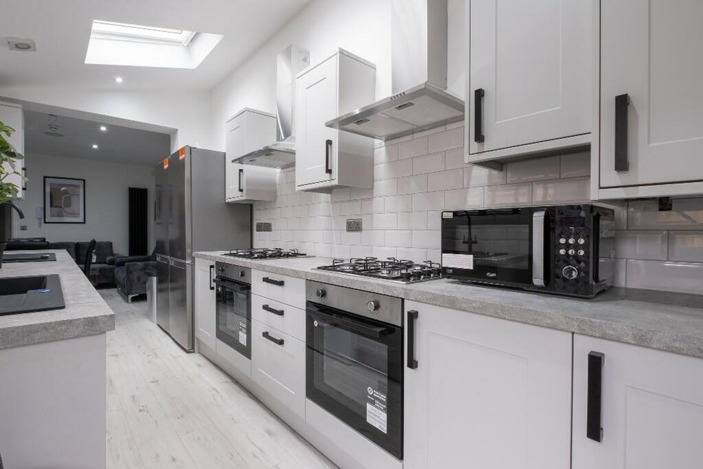 This modern kitchen features sleek cabinetry, a...
