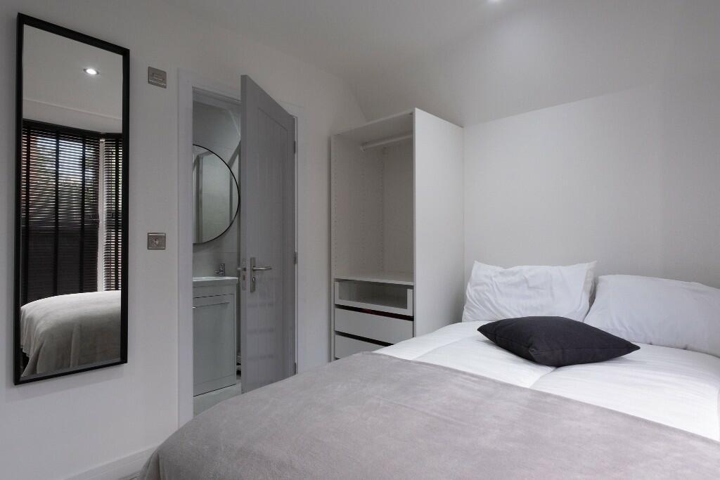 A bright and modern master bedroom featuring a ...
