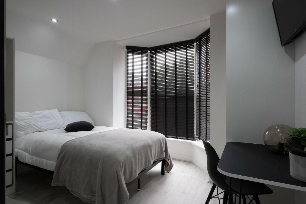 A spacious and modern master bedroom featuring ...