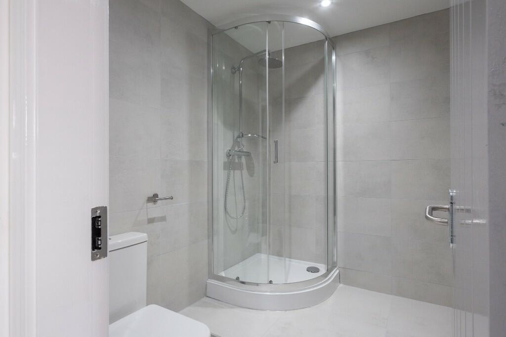 Modern bathroom featuring a spacious shower enc...