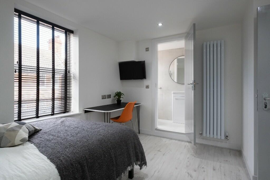 Bright and modern bedroom featuring a large win...