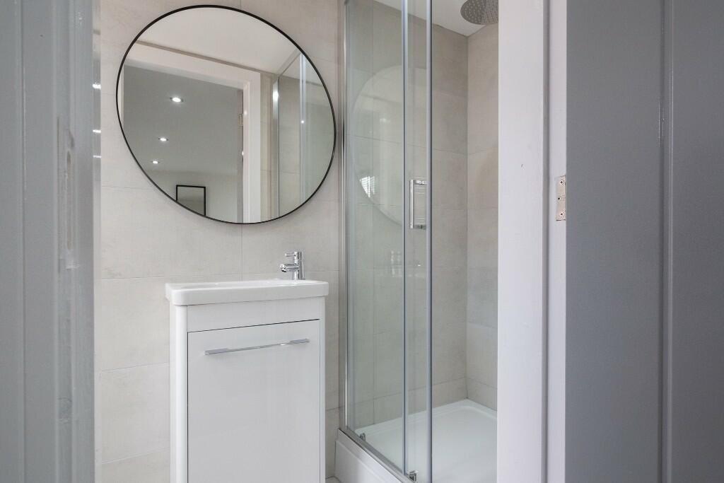 A modern, clean bathroom featuring a sleek show...