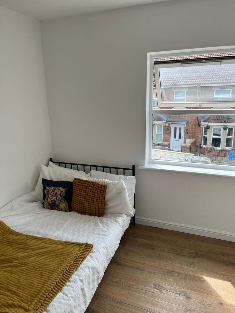 A cozy single bedroom featuring a comfortable b...