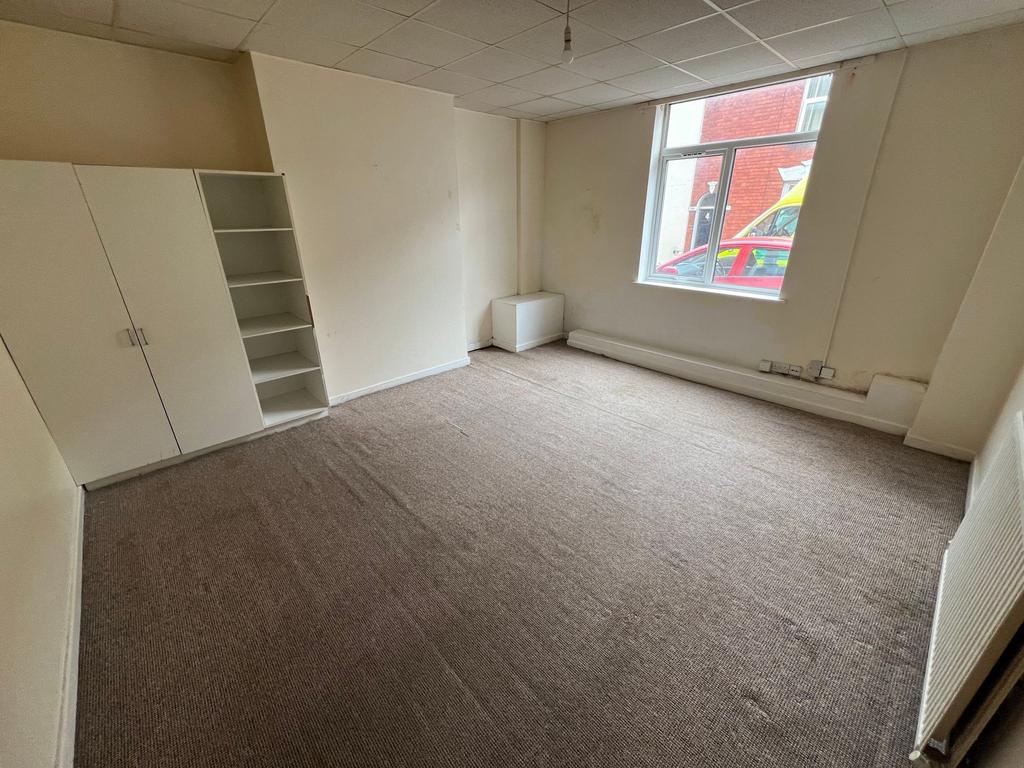 A simple, unfurnished single bedroom featuring ...
