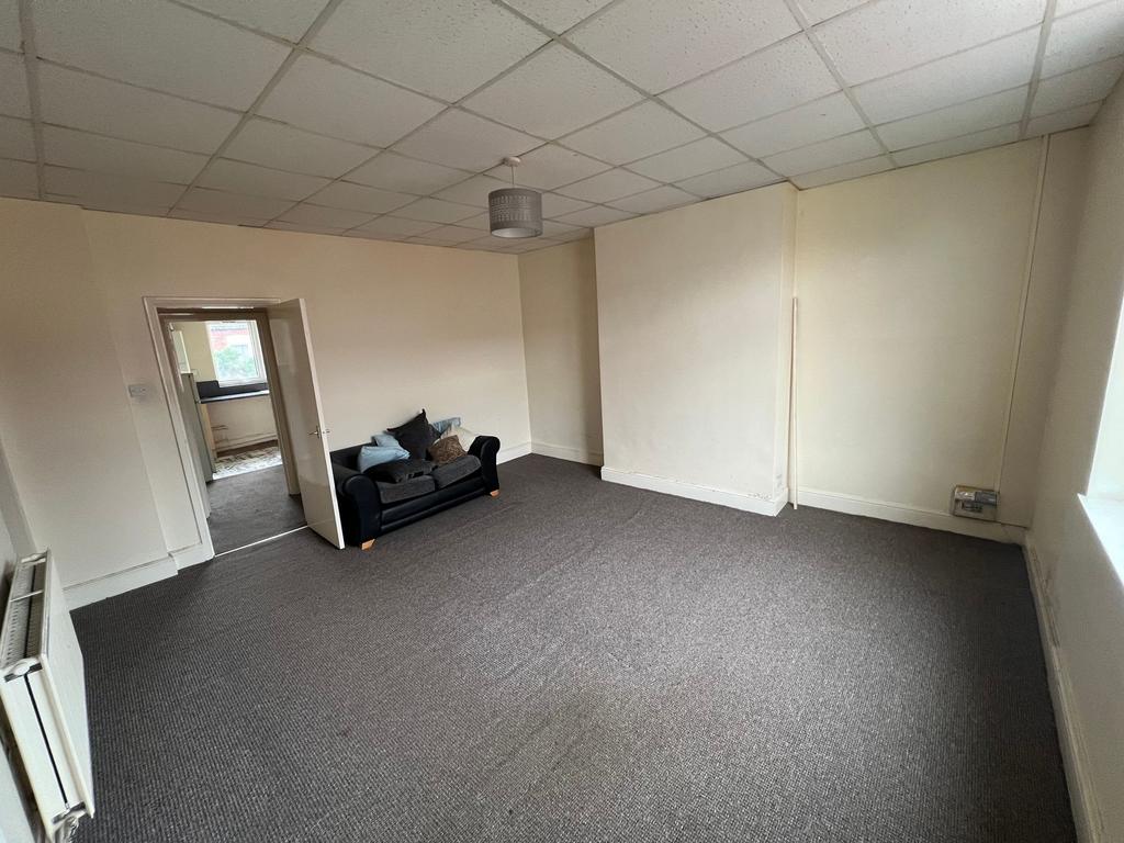 A spacious living room with neutral walls and a...