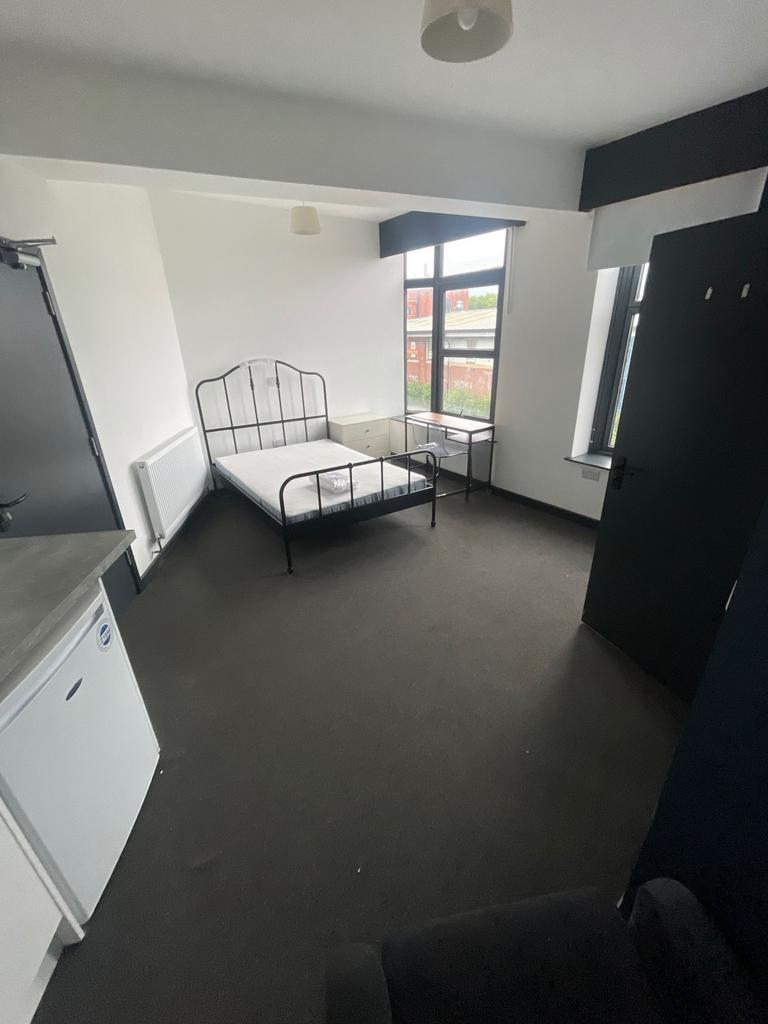 Bright double bedroom featuring large windows t...