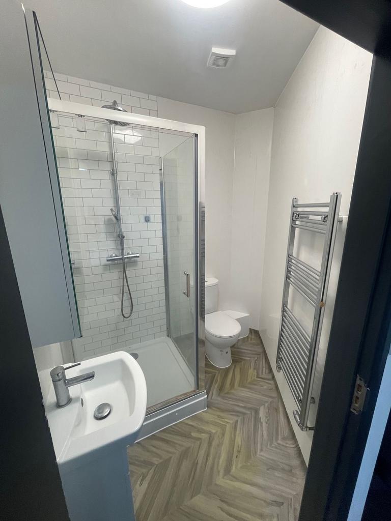Modern bathroom featuring a glass-enclosed show...