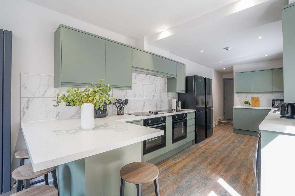 Bright and modern kitchen featuring stylish gre...