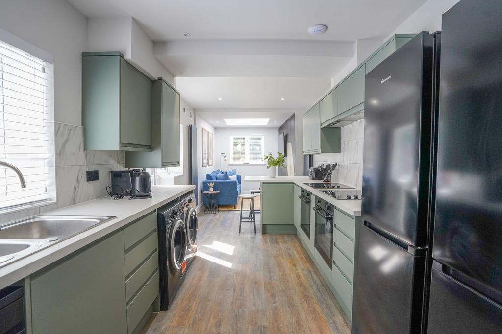 A modern kitchen featuring sleek cabinetry in a...