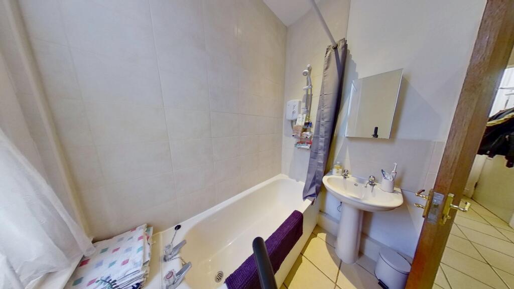 Bright bathroom suite featuring a clean white b...