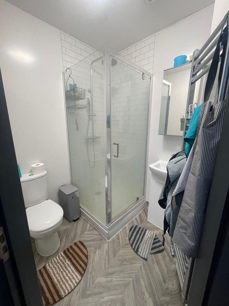 A modern and tidy bathroom featuring a glass-en...