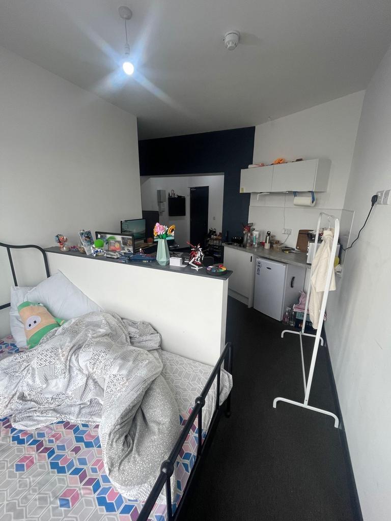 A cozy single bedroom with a comfortable bed, a...