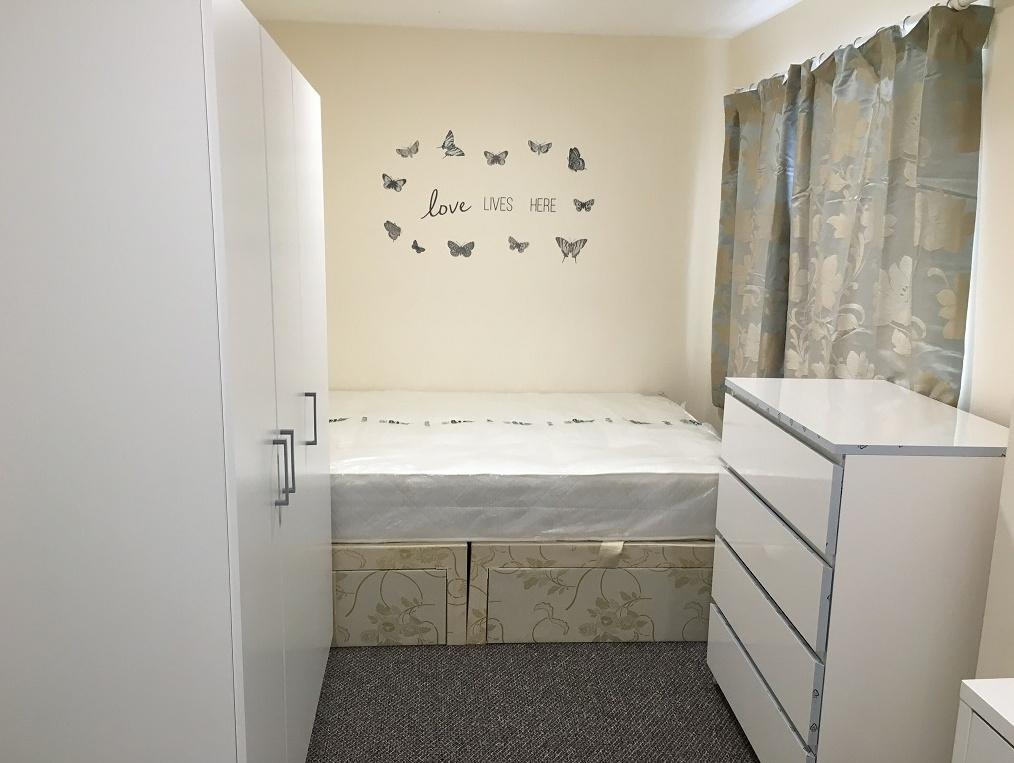 A bright and tidy single bedroom featuring a co...