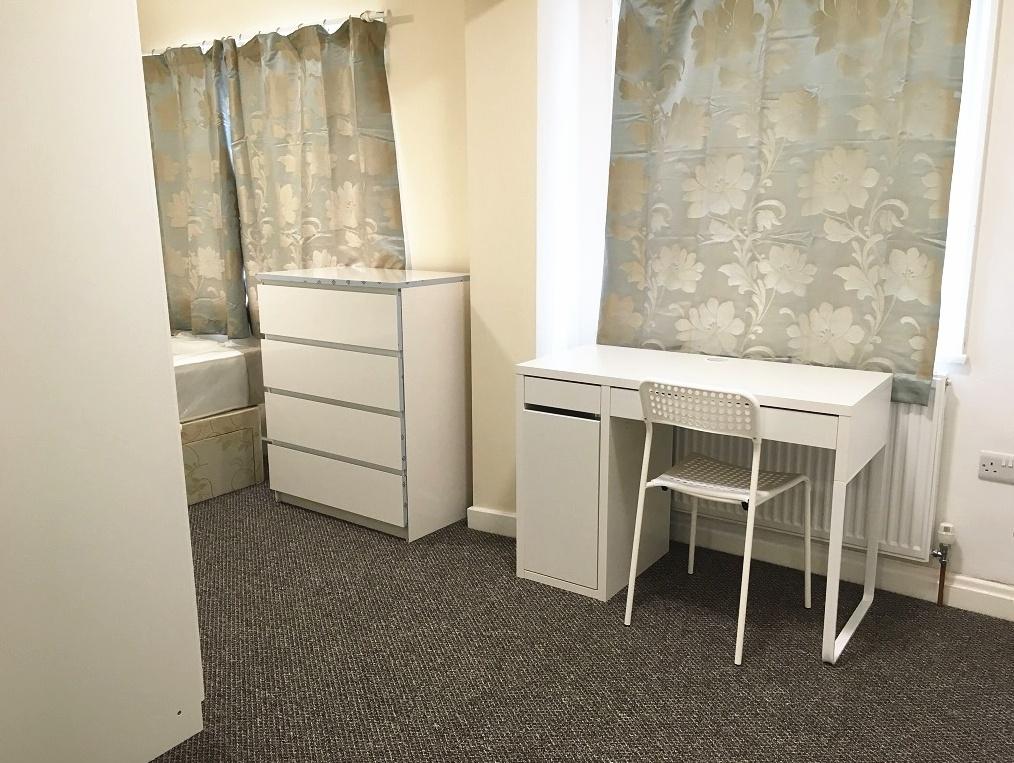 Bright and tidy single bedroom featuring a clea...