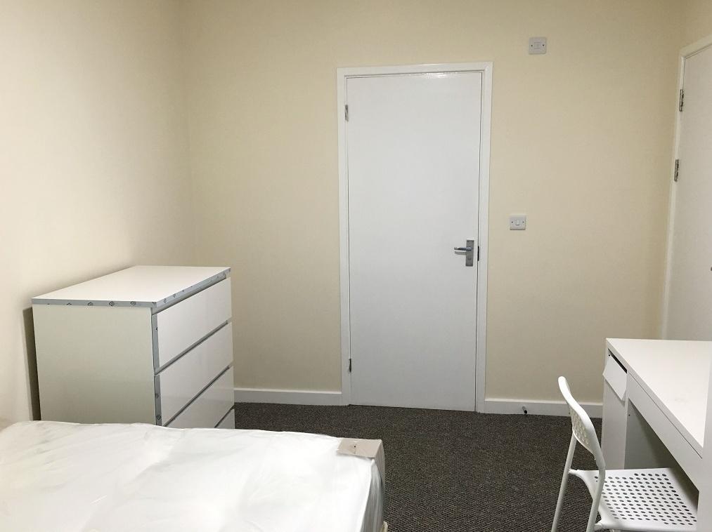 A neat and simple single bedroom featuring a wh...