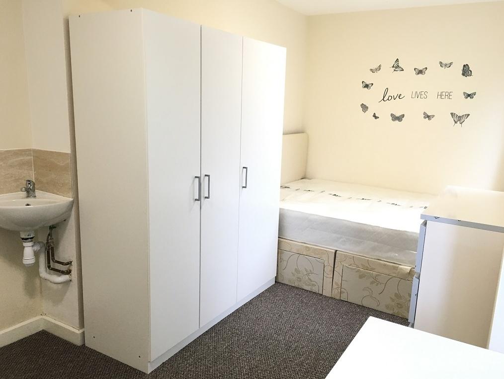 Bright and tidy single bedroom featuring a whit...