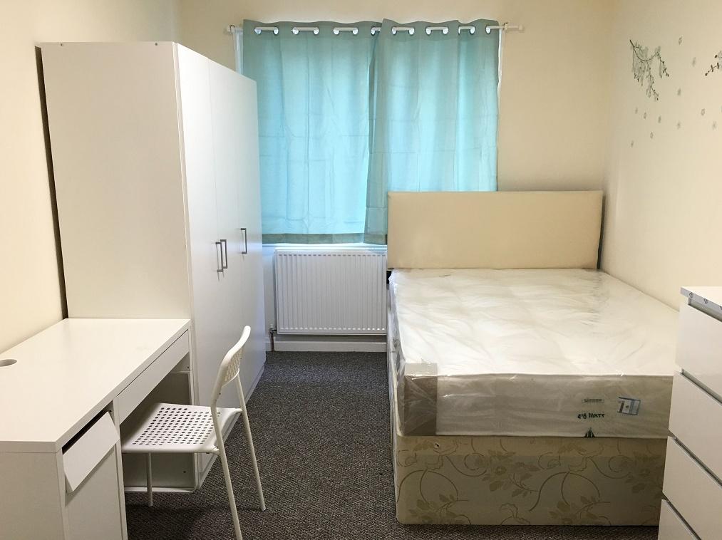 A neat and well-lit double bedroom featuring a ...