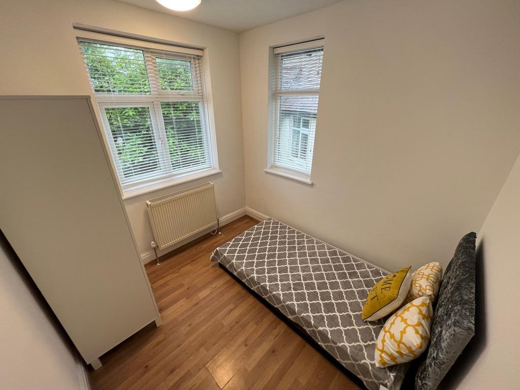 A bright and tidy single bedroom featuring two ...